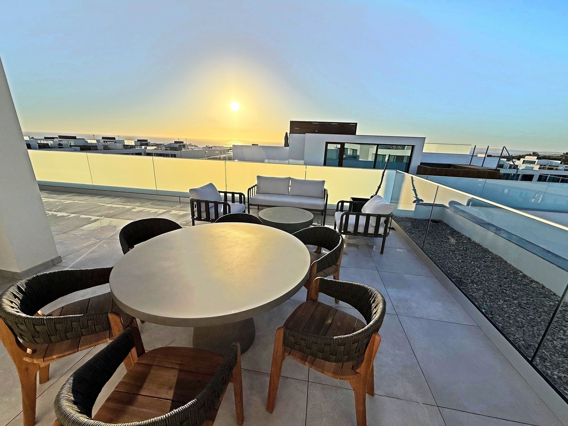 The private terrace at Blue Cove set for dinner as the sun drops to the sea